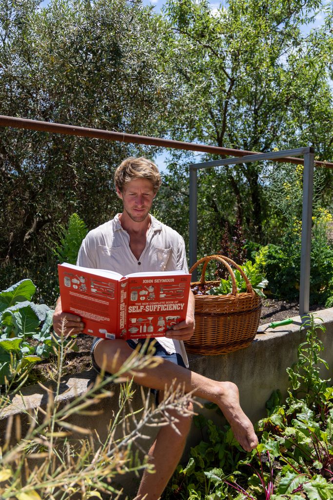 Hayo reading a book on self-sufficiency in the vegetable garden at Monte Valeo