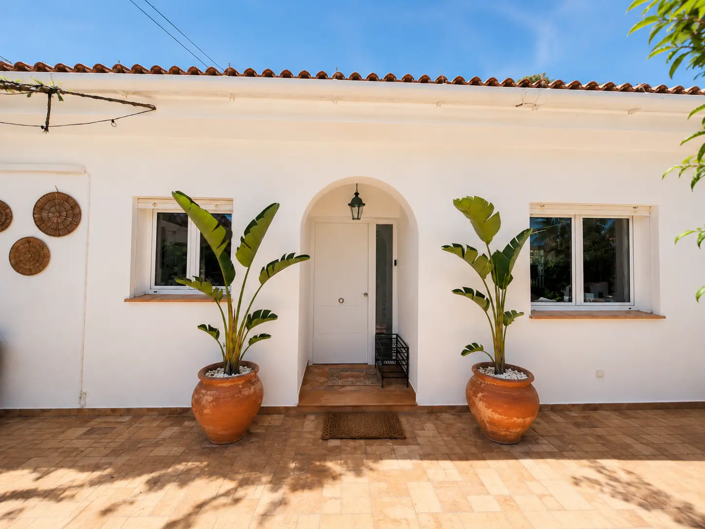 Whitewashed entrance with terracotta pots at Casa Con Alma