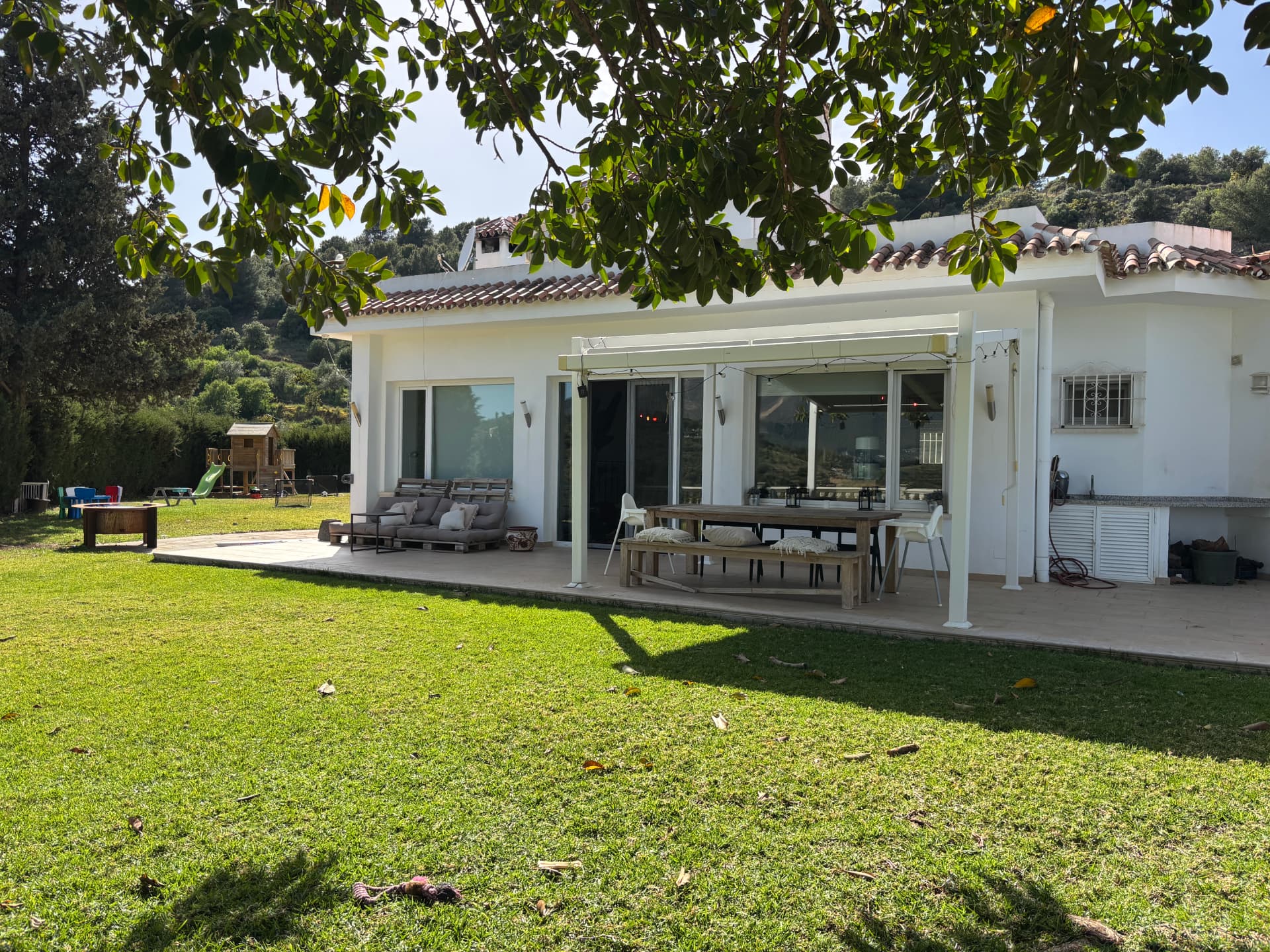 Covered terrace with long dining table at Villa Valeo