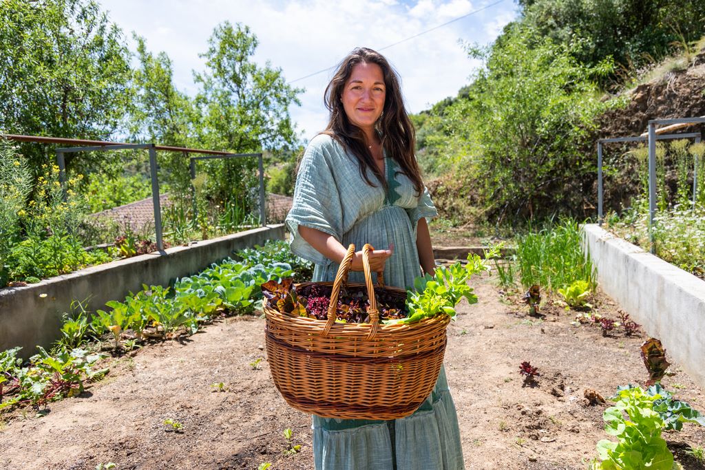 Nicole holding a basket of freshly harvested vegetables in the garden at Monte Valeo