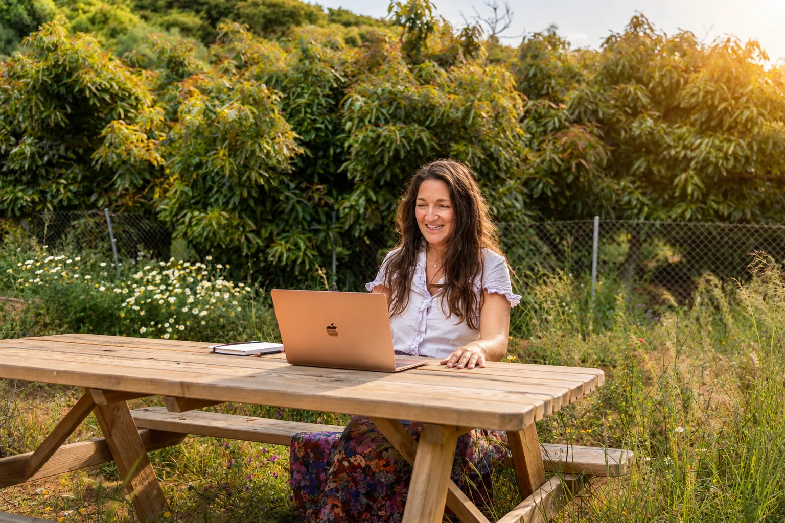 Working outdoors at a wooden table beside the avocado orchard at Monte Valeo