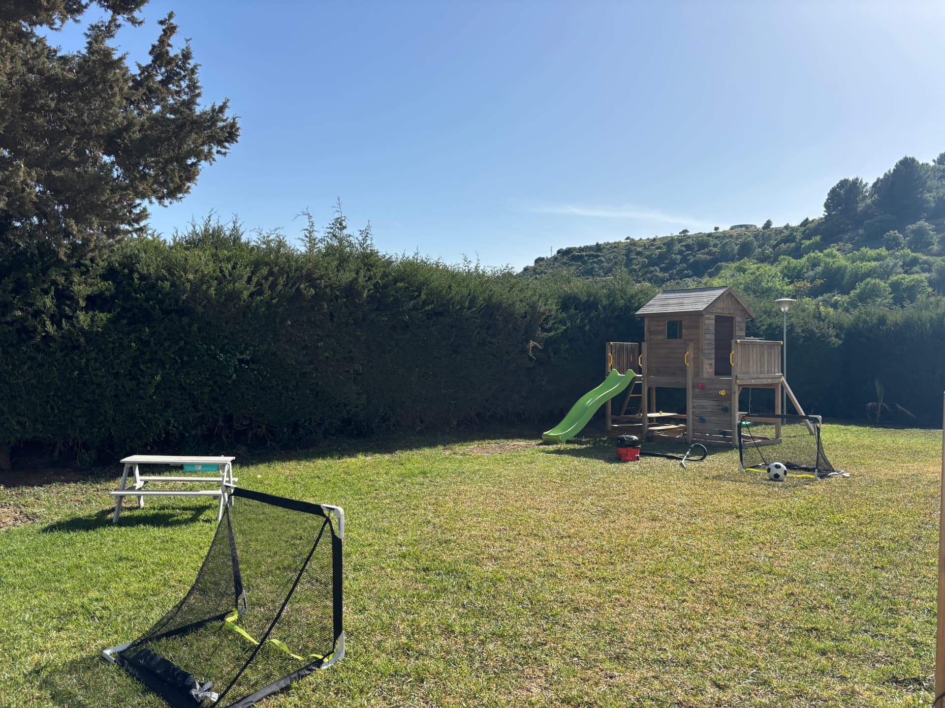 Wooden playhouse with slide in the garden at Villa Valeo
